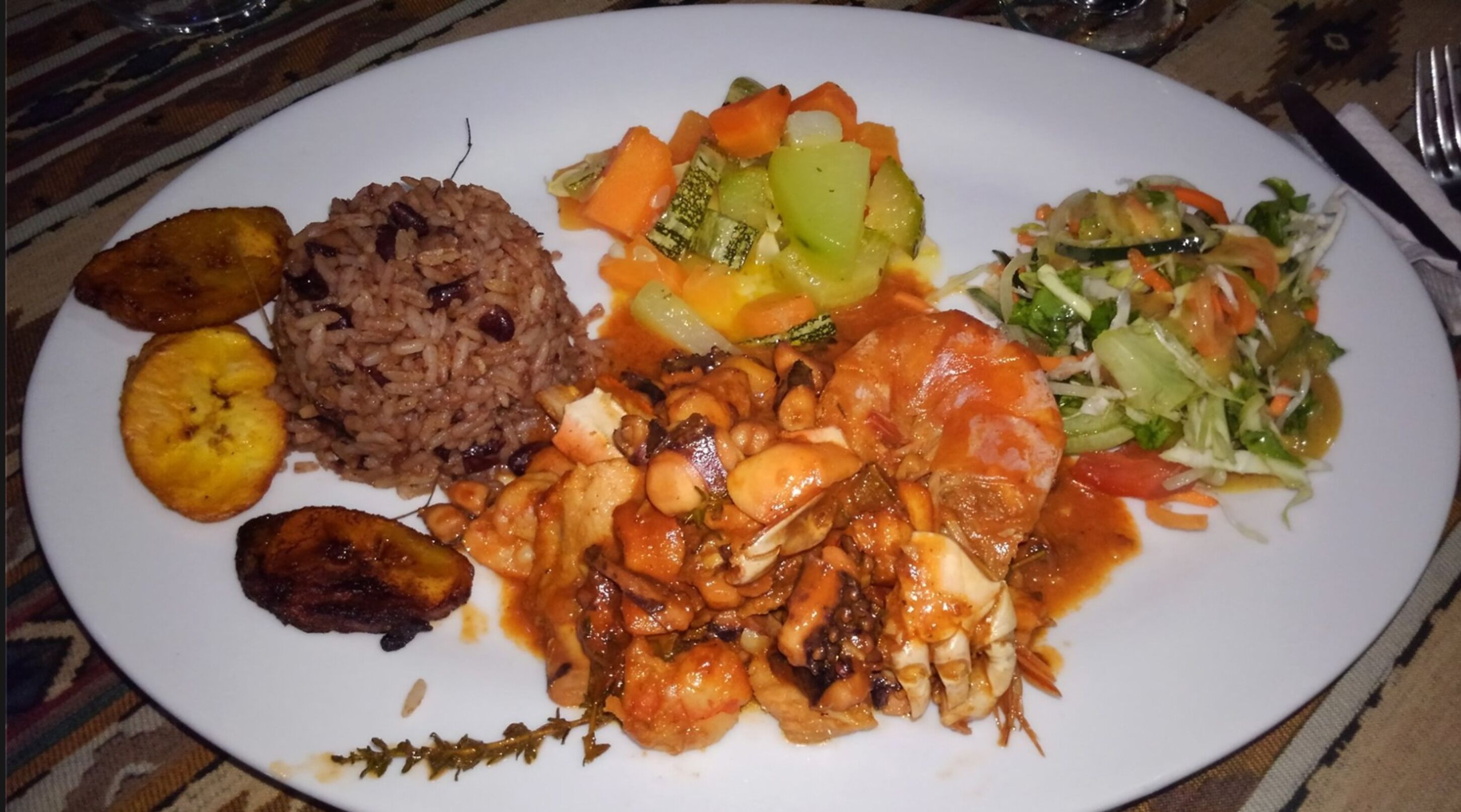 A plate of food including rice, vegetables, and a salad.