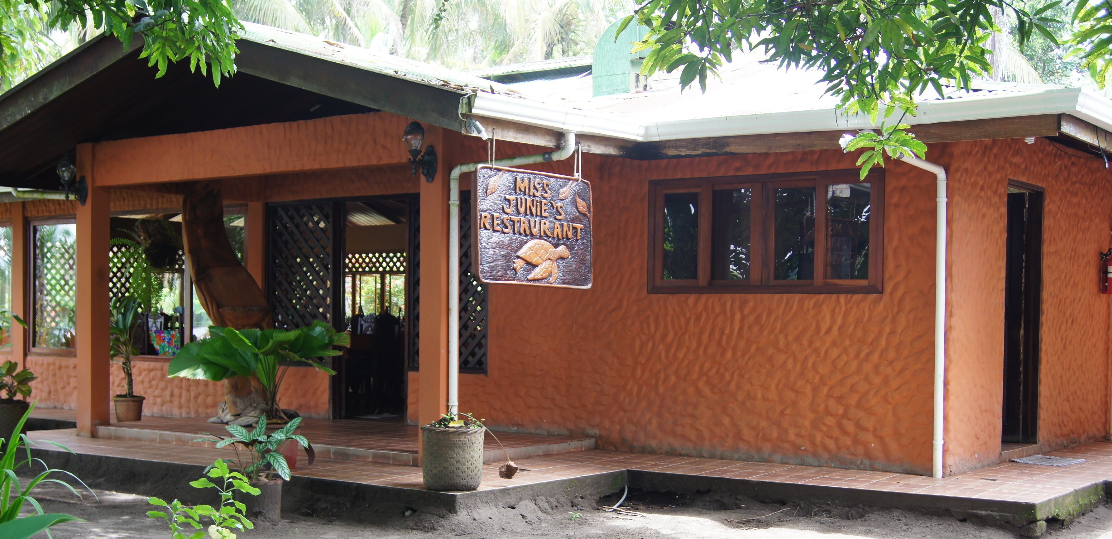 Un edificio rústico con un letrero que dice "Miss Junie Restaurant".