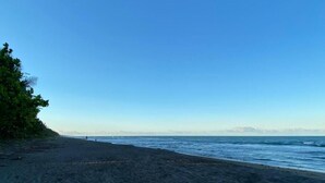 Uma praia com céu claro e mar calmo.
