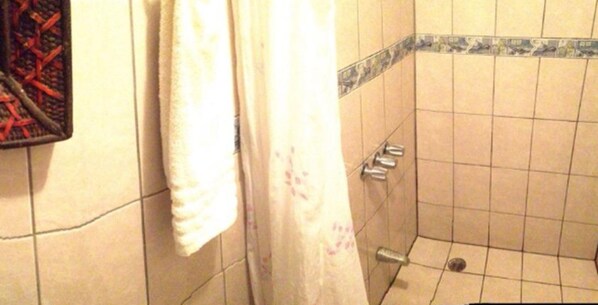 A bathroom with a shower, tiled walls, and a towel rack. - Miss Junies Lodge (Colorado)