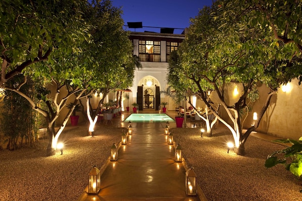 Una piscina al aire libre, sombrillas, sillones reclinables de piscina