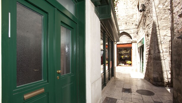 A narrow alleyway with a green door and a shop with a sign reading "Fok". - Prior Suites Split (Split)
