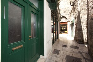 A narrow alleyway with a green door and a shop with a sign reading "Fok". - Prior Suites Split (Split)