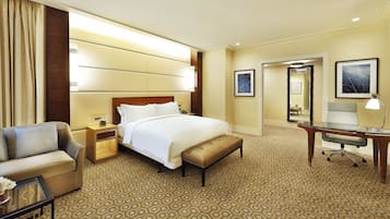 A hotel room with a large bed, a desk, a chair, a nightstand, and a mirror.