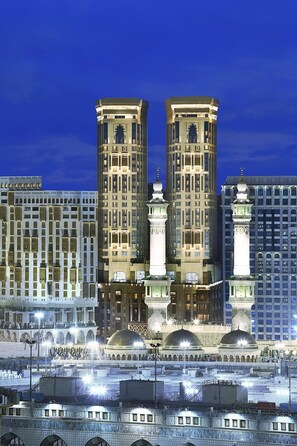 A large building with two prominent towers, a mosque with domes, and a busy urban environment. - Conrad Jabal Omar Makkah (Makkah)
