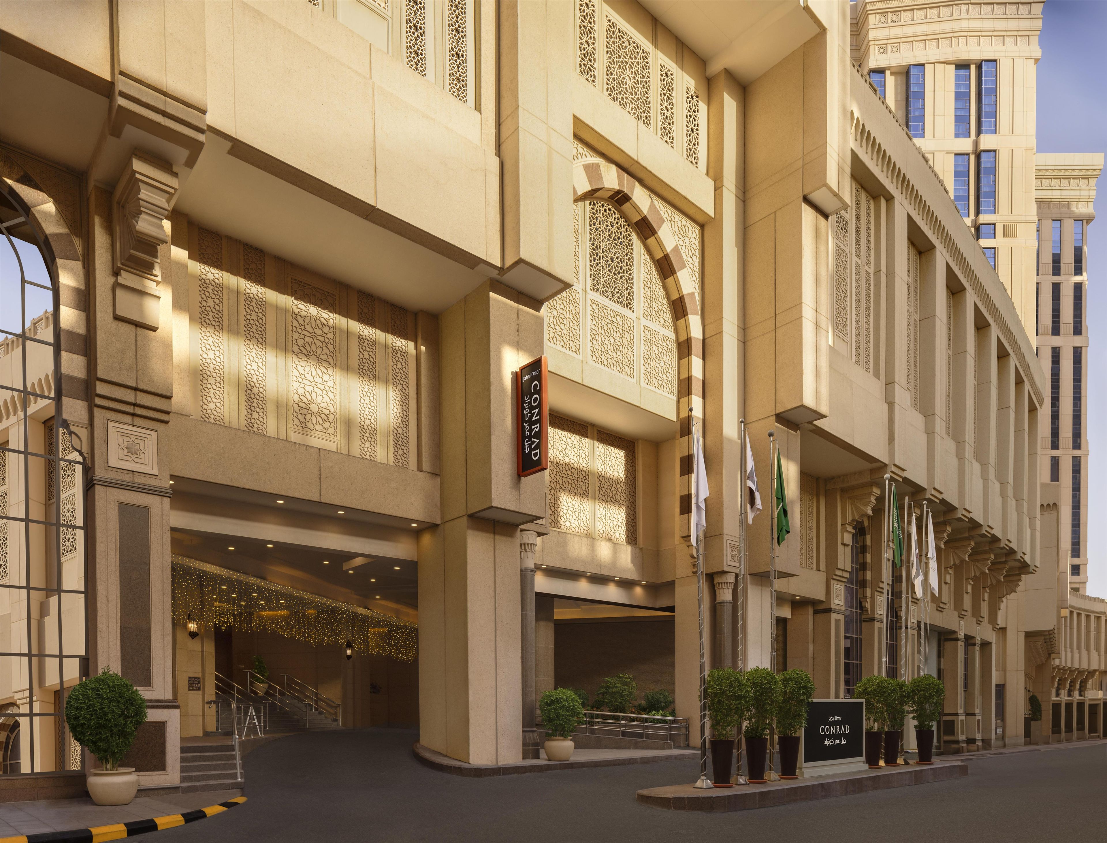 Entrada de hotel con un arco imponente, columnas y un letrero que indica el nombre del hotel.