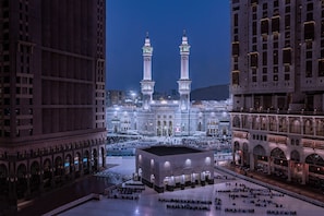 A large, modern building with two prominent towers, a spacious courtyard, and a large central area, likely a mosque.