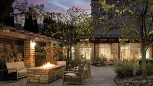 A patio area with a fire pit, outdoor seating, and a view of the building's exterior. - Courtyard by Marriott Gatlinburg Downtown (Gatlinburg)