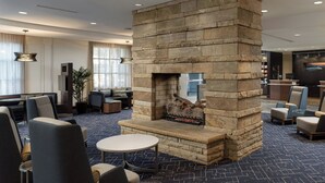 A lobby with a stone fireplace, seating area, and a reception desk. - Courtyard by Marriott Gatlinburg Downtown (Gatlinburg)