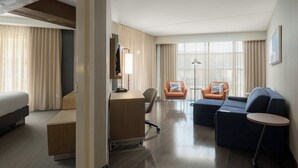 A hotel room with a bed, desk, two armchairs, a sofa, and a small round table. - Courtyard by Marriott Gatlinburg Downtown (Gatlinburg)