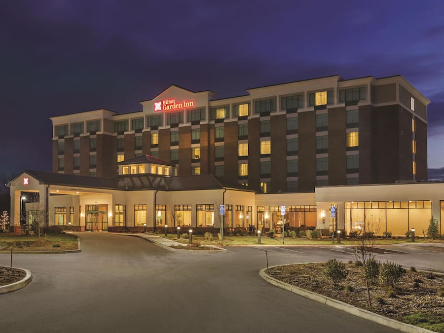 A multi-story hotel with a prominent entrance and a clear sky.