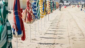 A beach with rows of umbrellas and beach chairs.
