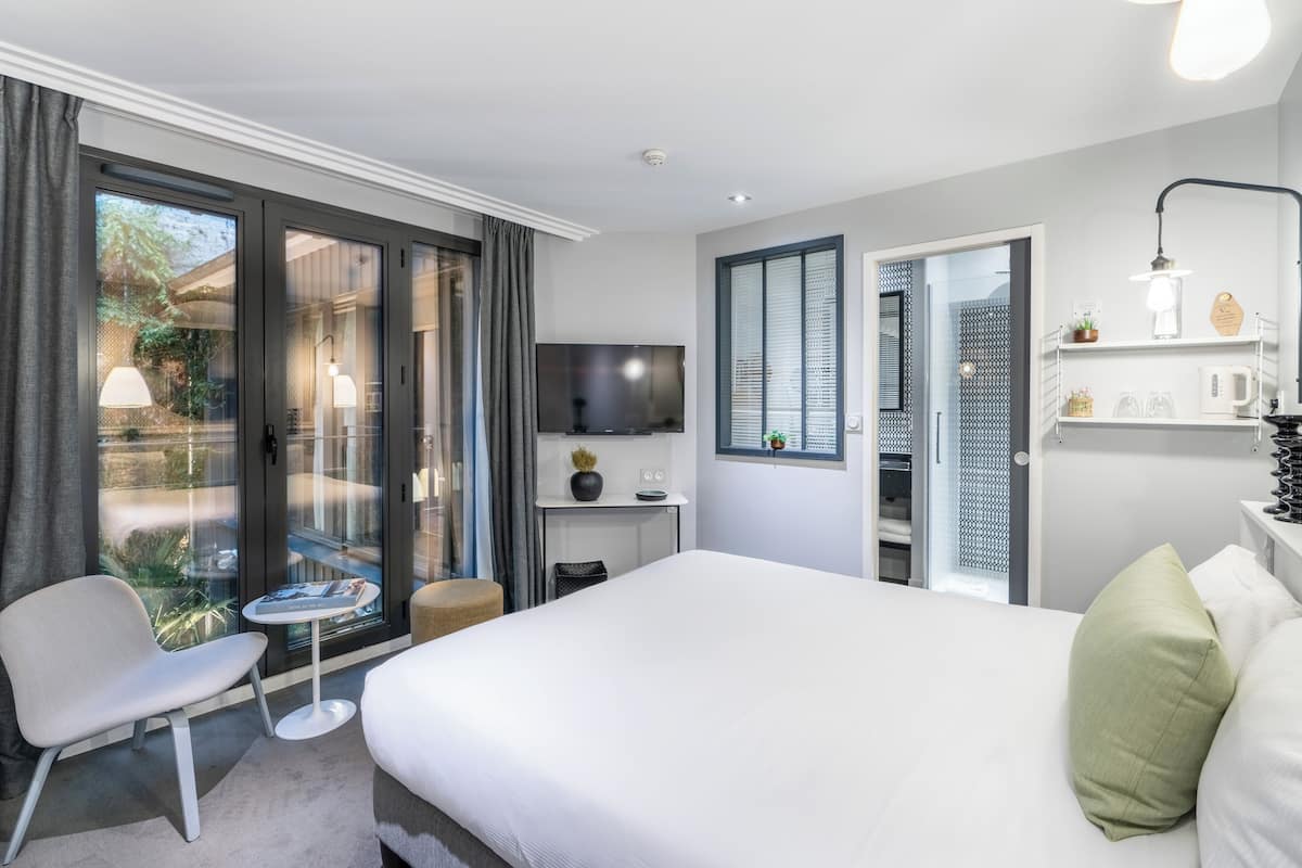 Deluxe kamer | Luxe beddengoed, een kluis op de kamer, een bureau, geluiddichte muren