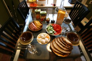A dining table set with various food items, including bread, eggs, tomatoes, and cheese.