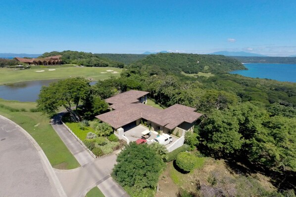 A house with a large garage, a driveway, and a view of a lake and mountains.