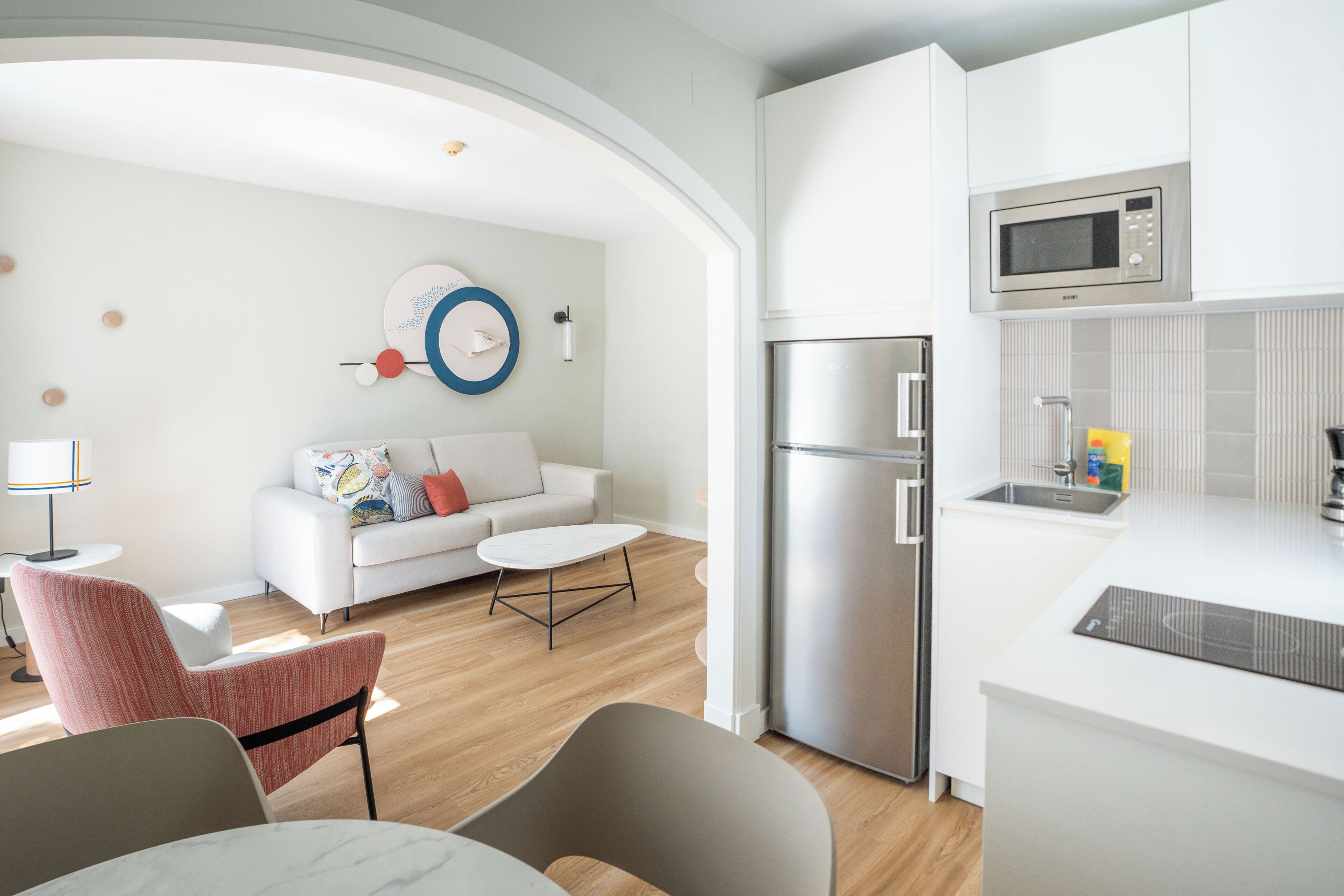 A modern kitchen with a built-in microwave, a refrigerator, and a sink.