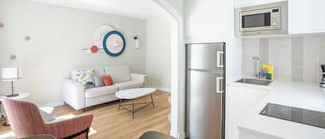 Una cocina moderna con microondas integrado, refrigerador y lavamanos.