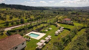 Piscina a l'aire lliure de temporada, para-sols i gandules