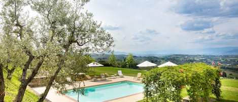 Piscina a l'aire lliure de temporada, para-sols i gandules