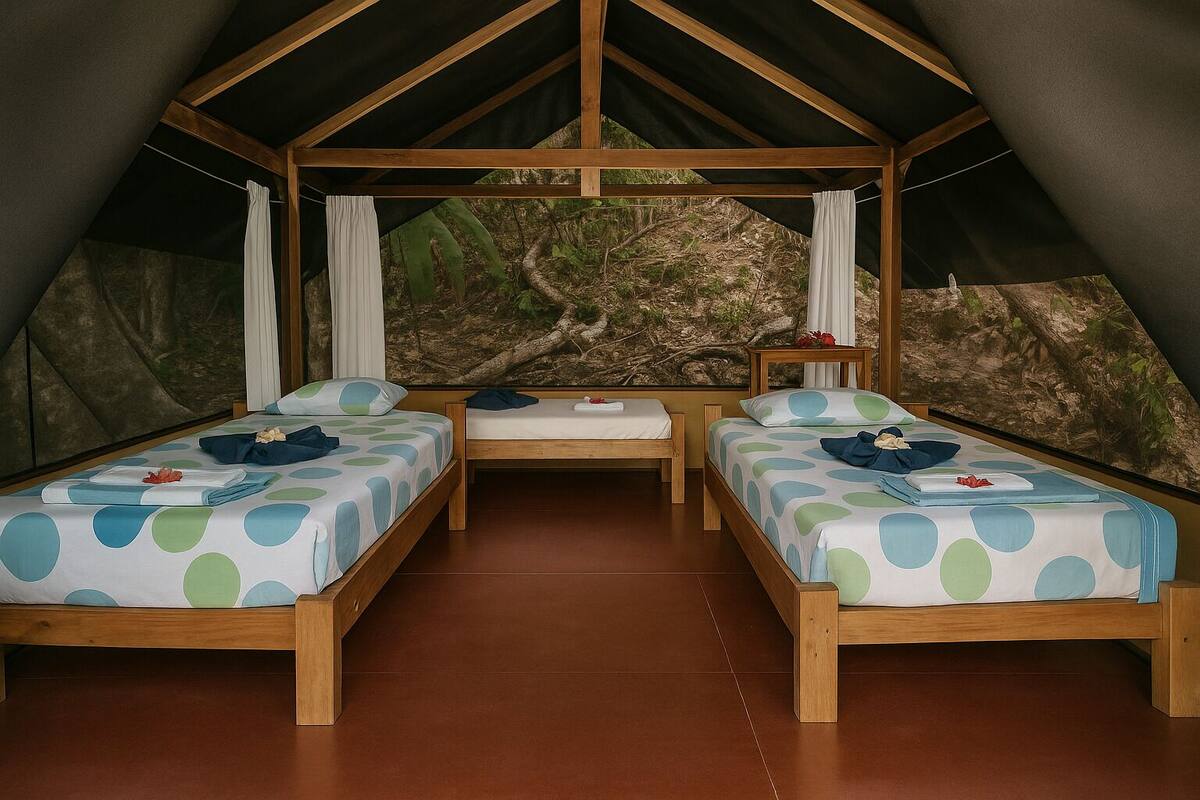 A tented accommodation with two single beds, a bench, and a view of a natural landscape.