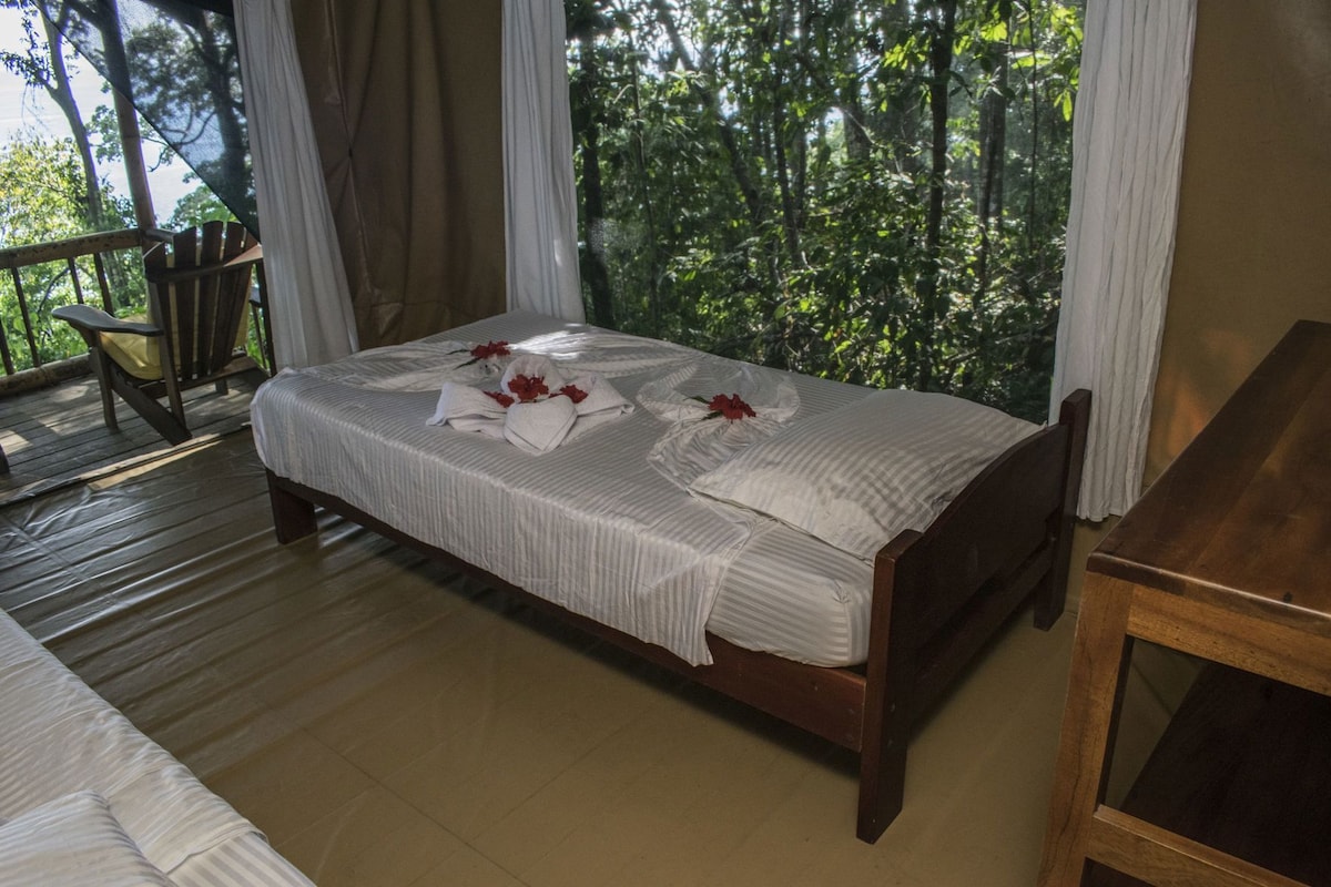 A bed with white linens, a wooden headboard, and a wooden table.