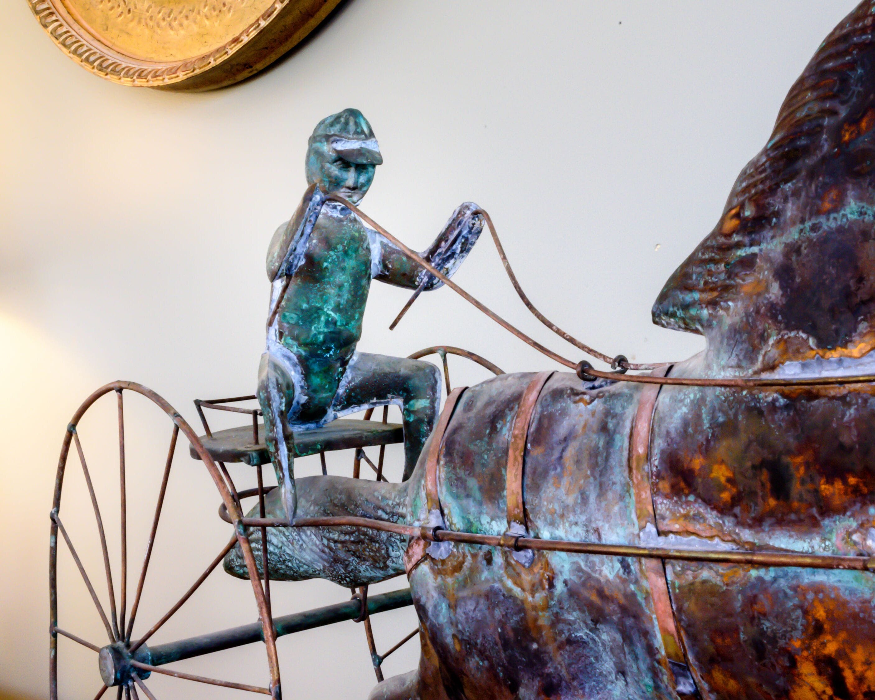 A bronze sculpture of a charioteer and horse.