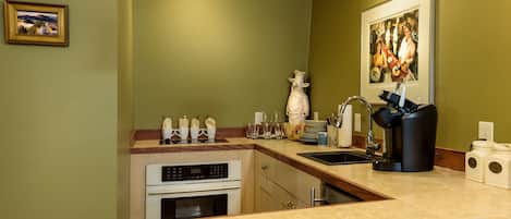 A modern kitchen with a built-in oven, a sink, and a countertop with various kitchen items.