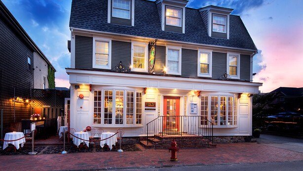 A two-story building with a prominent entrance, large windows, and a brick-paved front area. - Bouchard Inn (Newport)