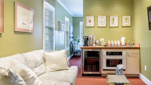 A compact living space with a kitchenette, a dining area, and a seating area with a sofa. - Bouchard Inn (Newport)