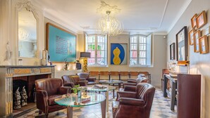 Un salón amplio con sillones de cuero, una mesa de centro de vidrio y una chimenea.