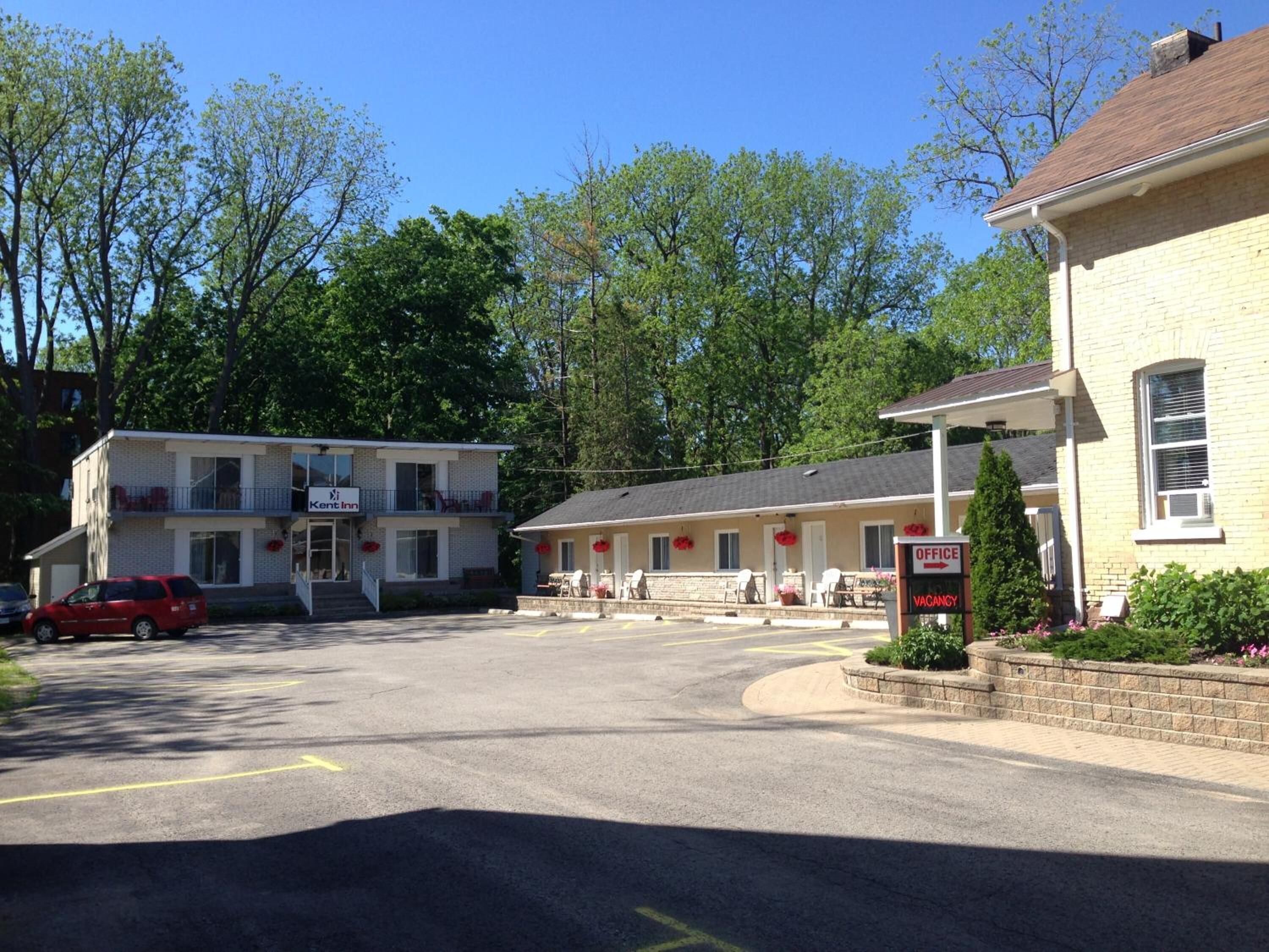 A motel with a two-story building, a parking lot, and a sign indicating an office and vacancy.