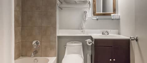 A bathroom with a bathtub, toilet, sink, and a mirror.