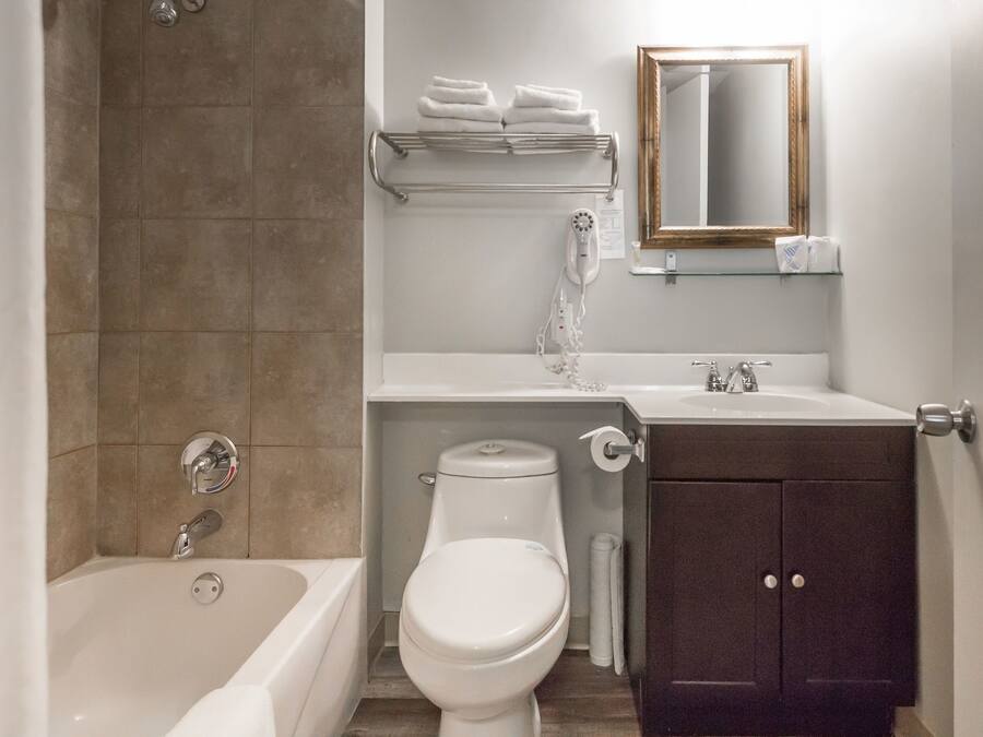 A bathroom with a bathtub, toilet, sink, and a mirror.