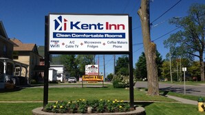 Letrero del Kent Inn que enumera comodidades como WiFi gratuito, aire acondicionado, microondas, cafetera y televisión por cable.
