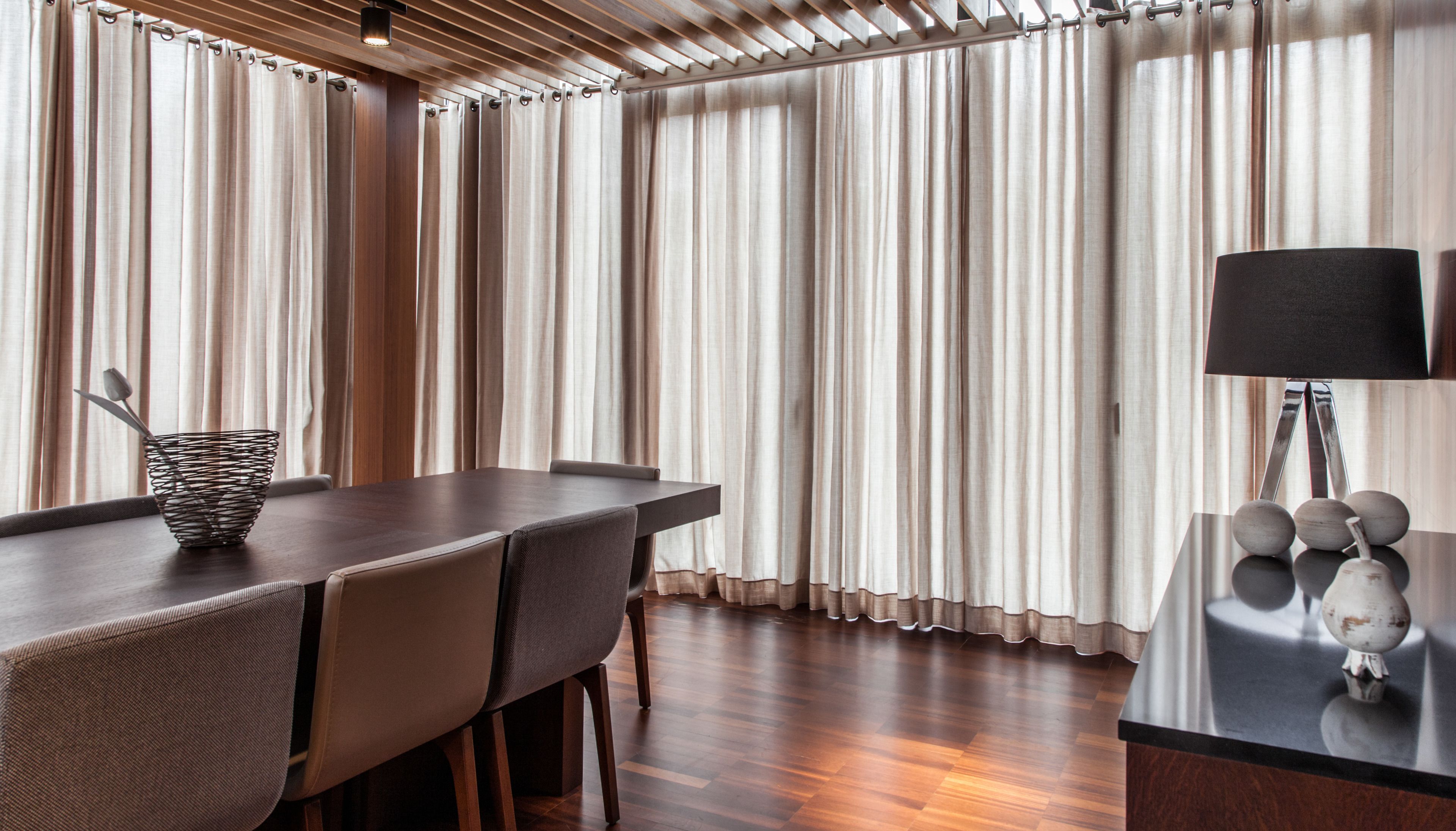 A modern dining area with a wooden table, chairs, and a decorative lamp.