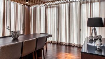 Uma sala de jantar moderna com uma mesa de madeira, cadeiras e um abajur decorativo.