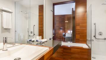 Een moderne badkamer met een grote spiegel, twee wasbakken en een douchegedeelte.