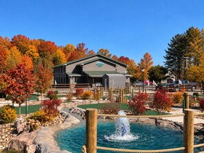 Eine Lodge mit Schwimmbad, umgeben von Herbstlaub.