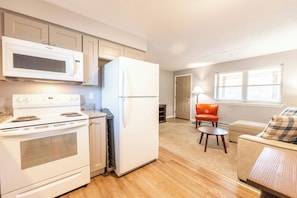 A compact kitchen with a microwave, stove, and refrigerator.