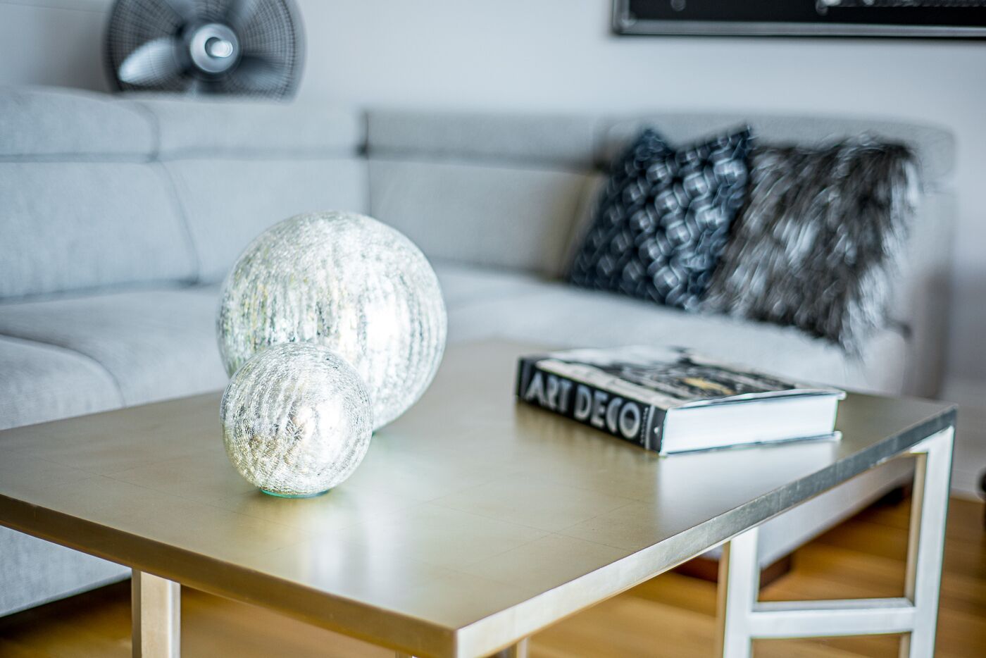 Ein modernes Wohnzimmer mit einer Couch, einem Couchtisch und dekorativen Kugeln.