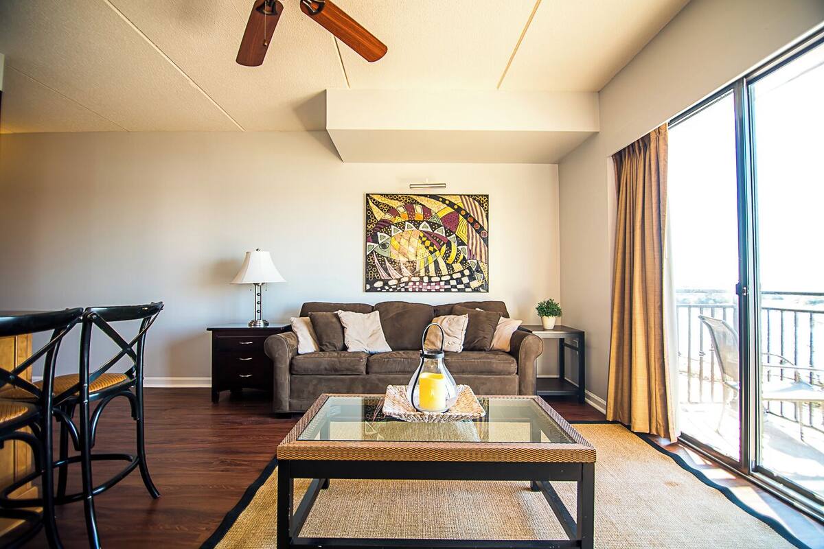 A living room with a sofa, a coffee table, a lamp, and a painting on the wall.