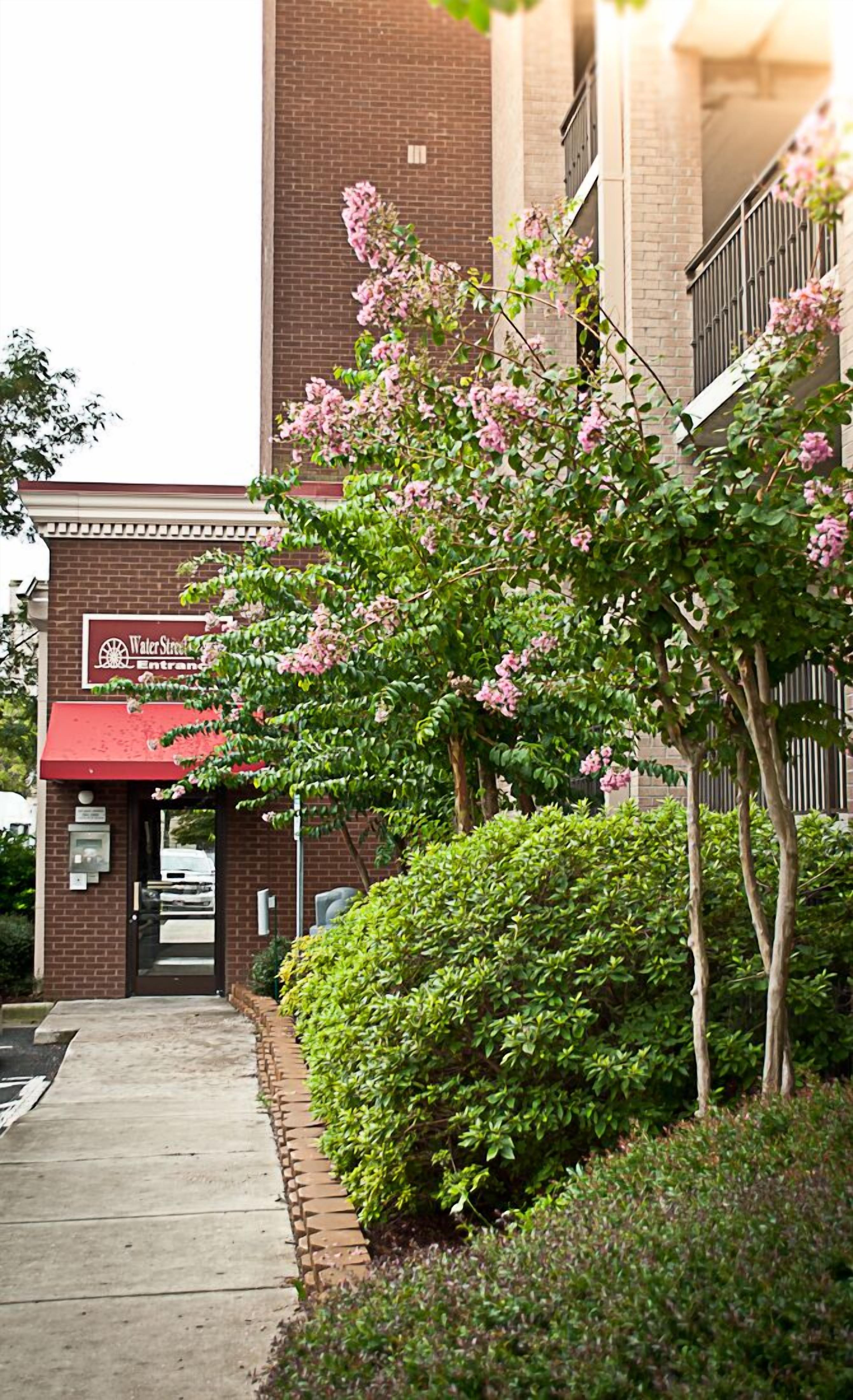 A building with a brick facade, a red awning, and a sign that reads "Water Street Entrance."