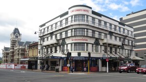 A multi-story hotel with a prominent "Law Courts Hotel" sign, a "Jury Room Bar" on the ground floor, and a "Vacancy Tonight" sign. - Law Courts Hotel (Dunedin)