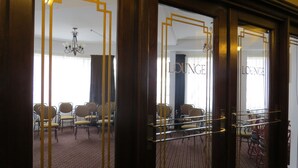 A lounge area with rows of chairs and a chandelier. - Law Courts Hotel (Dunedin)