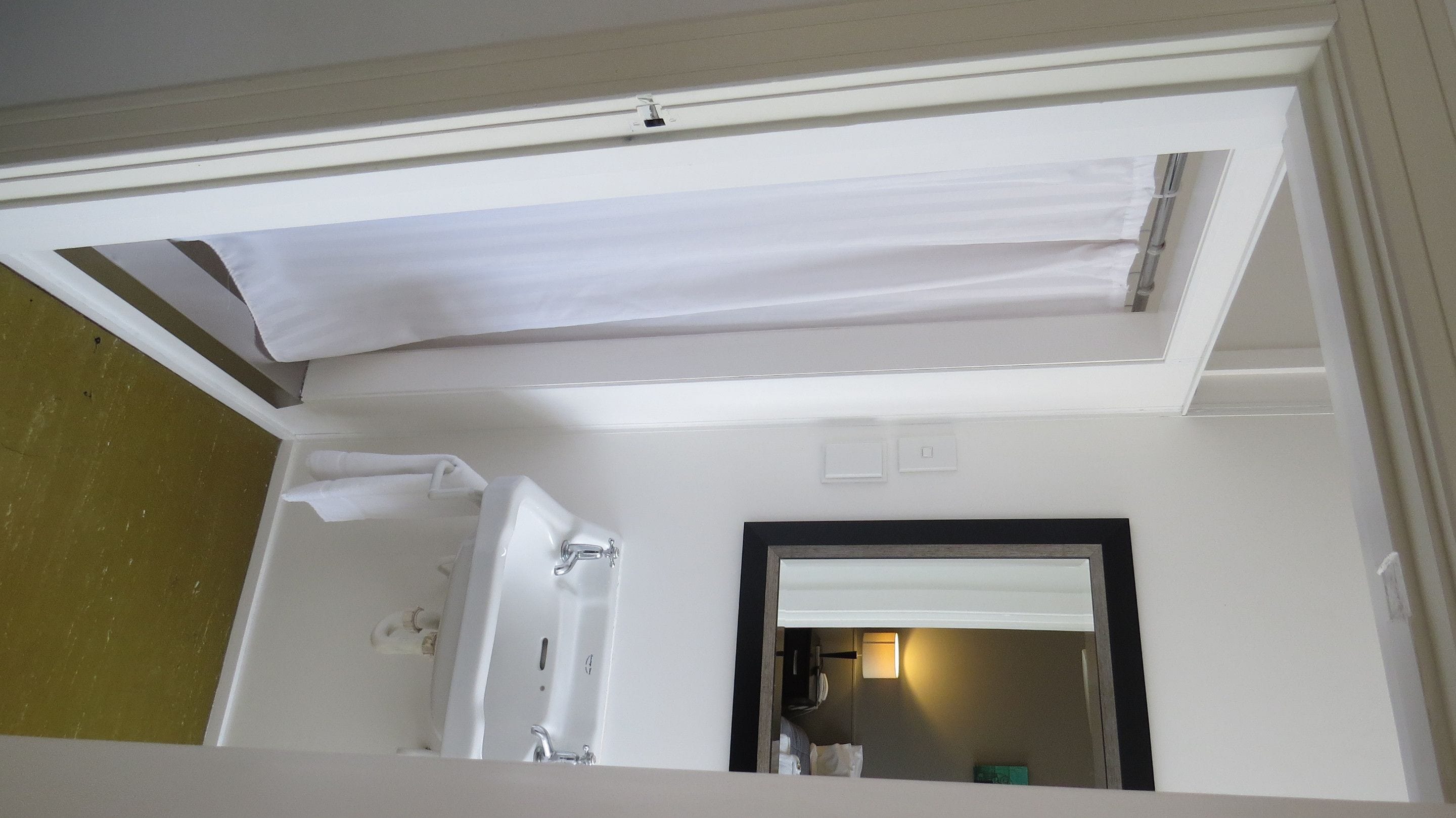 A bathroom with a bathtub, a shower, and a mirror.