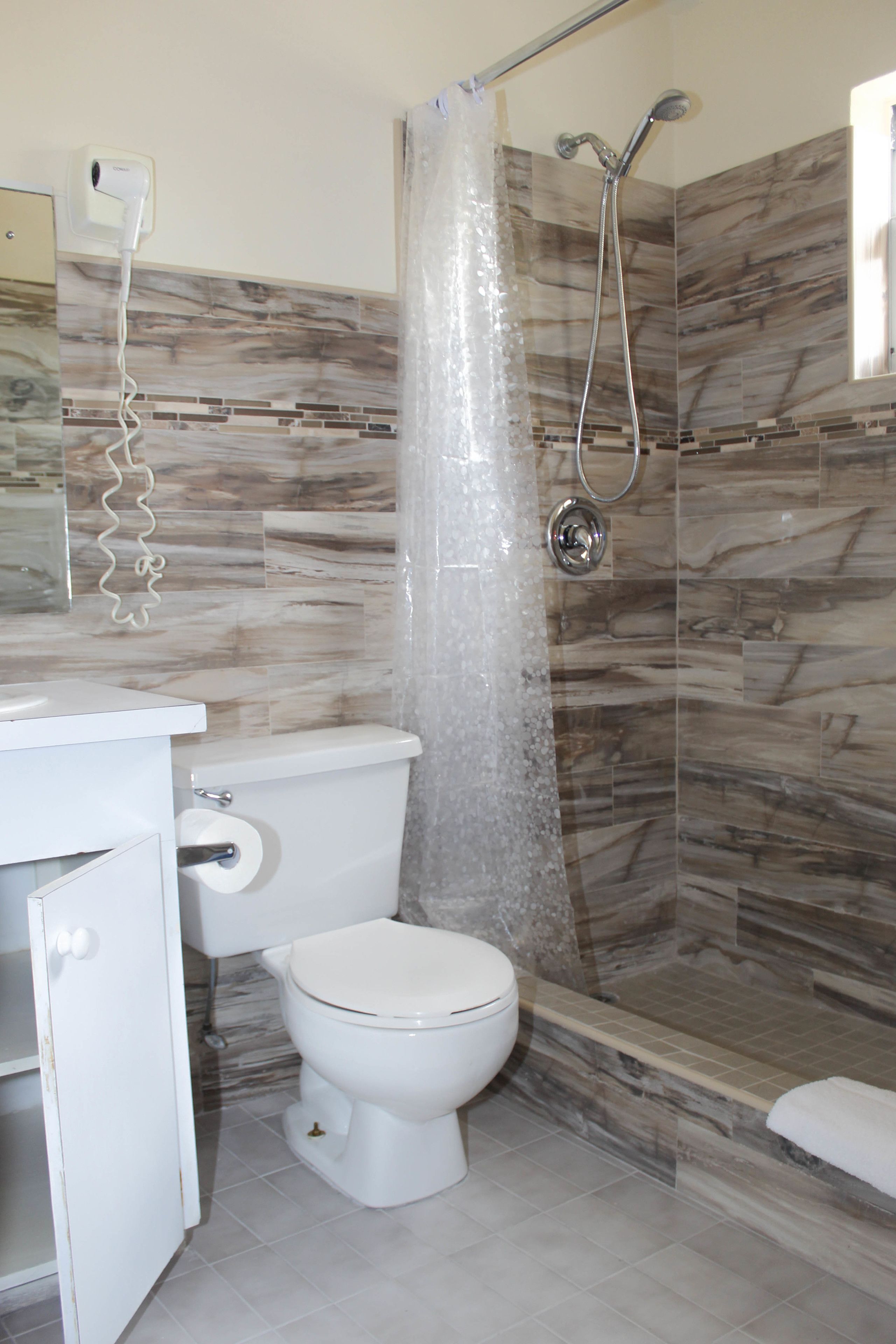 Un bagno con doccia, WC e lavabo.