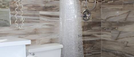 Un bagno con doccia, WC e lavabo.