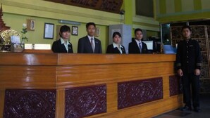 A reception desk with a chandelier, a sign reading "Summer Police Museum," and clocks on the wall. - Summer Palace Hotel (Yangon)