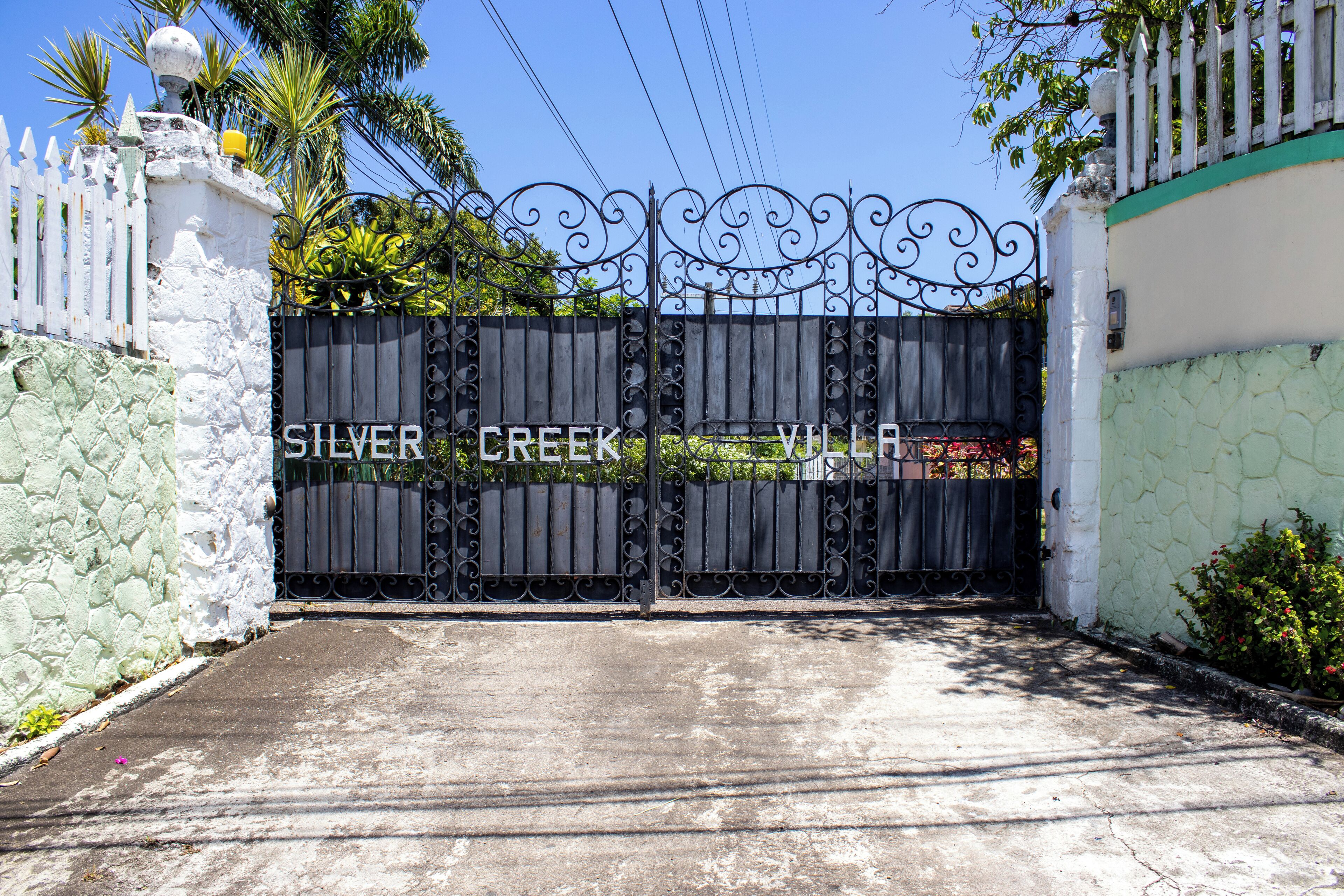 A gated entrance with the text "SILVER CREEK VILLA" on a metal gate.