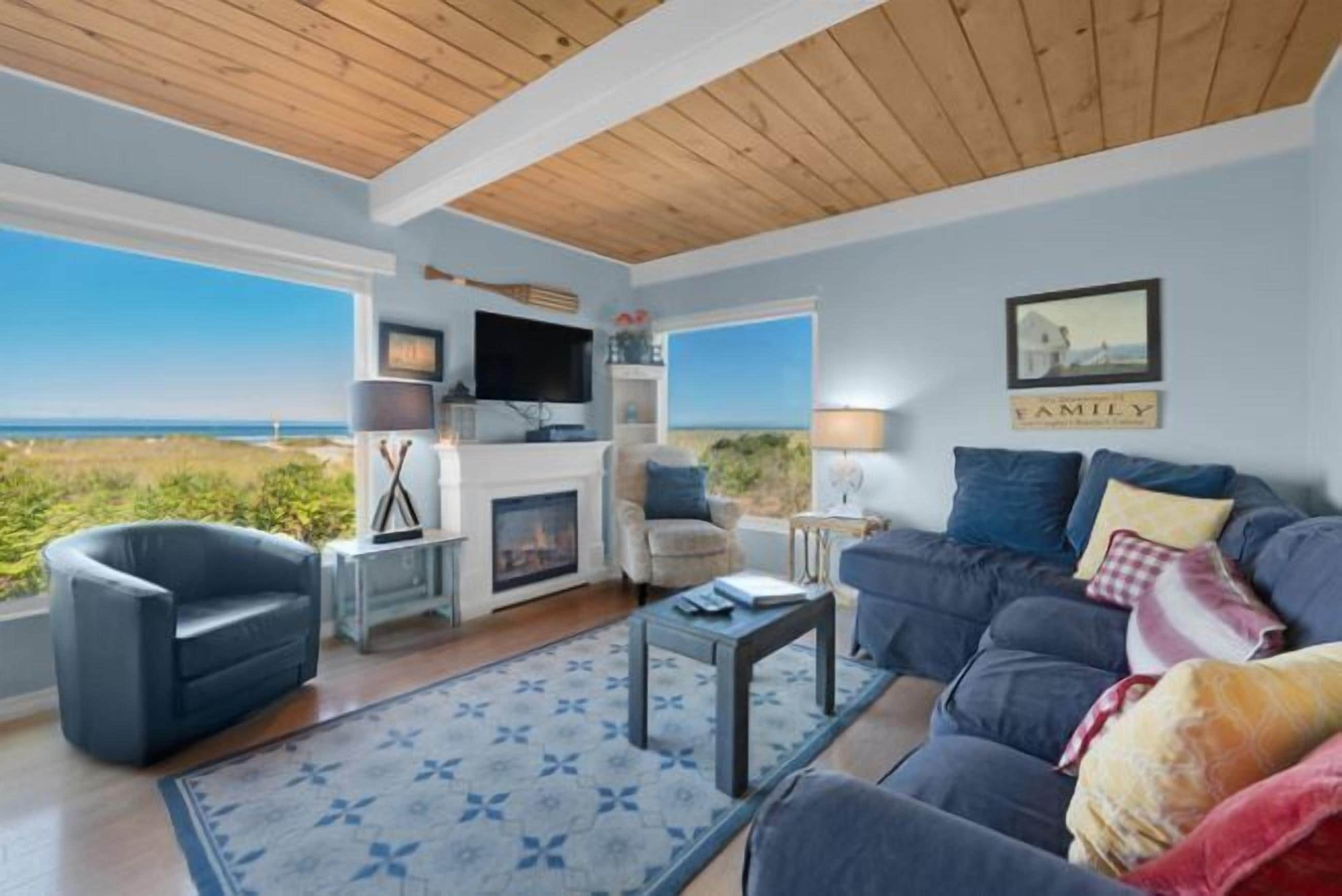 A living room with a fireplace, a sofa, a chair, and a television.